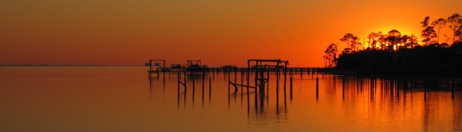 Orange sunset over calm water and docks on the Florida Panhandle