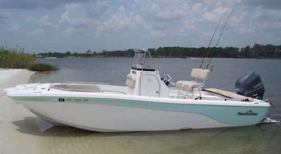 White and seafoam NauticStar bay boat beached on a sandy shoreline